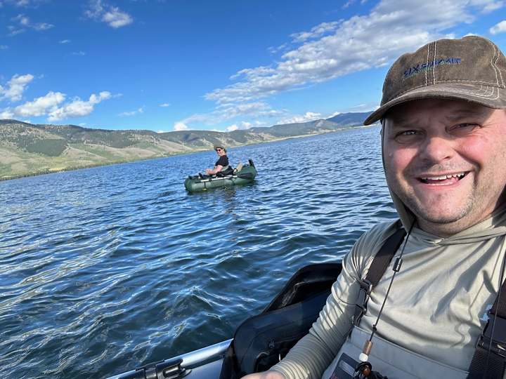 Jeff fly fishing in the mountains, wearing a Six Summit hat